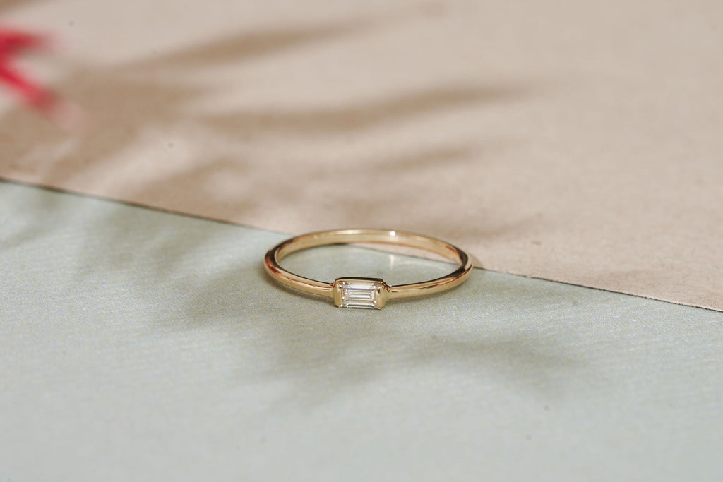 https://ik.imagekit.io/fzkghjurk1l/resize-external/https://storage.googleapis.com/shop_images/Akind/AKIND_BaguetteDiamondRing_Enviro.jpg?tr=w-2000,h-2000,c-at_max,f-jpg,bg-white