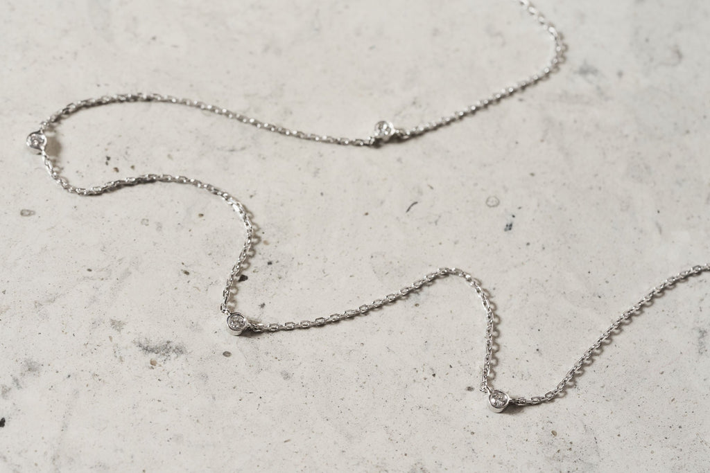 https://ik.imagekit.io/fzkghjurk1l/resize-external/https://storage.googleapis.com/shop_images/Akind/AKIND_StationDiamondNecklace_WG_Enviro.jpg?tr=w-2000,h-2000,c-at_max,f-jpg,bg-white
