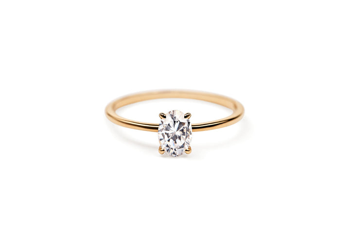 https://ik.imagekit.io/fzkghjurk1l/resize-external/https://storage.googleapis.com/shop_images/Akind/AKIND_OvalCutDiamondRing0.5Ct_Laying_YG_Studi.png?tr=w-2000,h-2000,c-at_max,f-jpg,bg-white