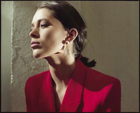 Tropfen Sie weiße Lippen aus, vergoldete Ohrringe